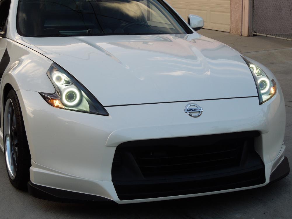 Halos

Update: Bumper/finisher/lip $😀LD after conversion to Nismo.

Nismo Nose Finisher
Sunline rep
Paint scheme

-------------

Installed a Nissan front bumper finisher before the headlight mod.

More about the headlight install on this link:
[URL="http://www.the370z.com/members-370z-gallery/81231-axmea-s-not-much-build-thread-more-like-photo-log-5.html#post2901122"]http://www.the370z.com/members-370z-gallery/81231-axmea-s-not-much-build-thread-more-like-photo-log-5.html#post2901122[/URL]

July 18 install. Work done by George at GY Custom Lighting aka paperboy.

RetrofitSource STi-R and FX-R Clear Lenses - Headlights and signal lights.
Top and bottom Morimoto XB Angel Eyes.
Black housing
White Shroud

The STi-R clear lenses provide brighter, clearer, and sharper output than the stock lenses. This is a great mod in itself. The angel eyes however makes it way better and enhances the set. While the black housing and white shroud ads personality. It gives the car a great look.