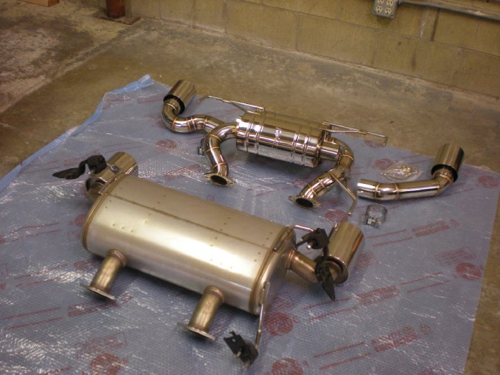 Old OEM Nismo muffler section with hangers compared to new Meisterschaft system
