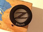 Z logo cut out placed on button inside housing