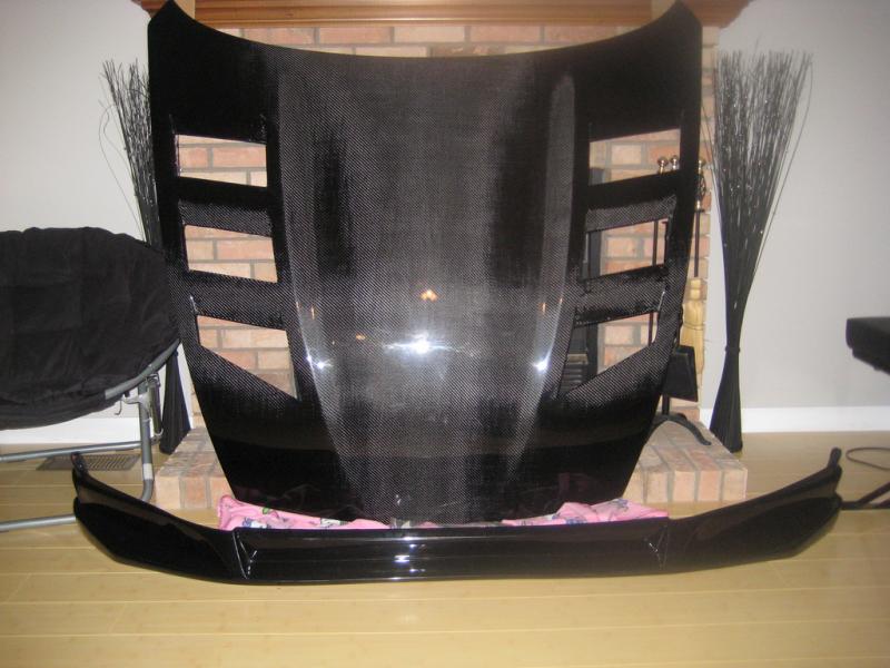 My carbon fiber vented hood (IGNORE THAT PINK HELLO KITTY BLAKET!  ITS MY WIFE's..i was using it so the hood can rest on it lol) and my SL front lip (urethane)