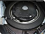 Bose subwoofers enclosure atop and in recess of spare tire.