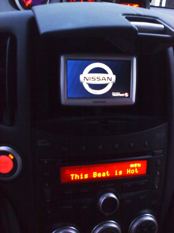 This was removed sometime ago and replaced with a phone mount with combo power / auxiliary audio cable.  

Fix mounted, hard wired Tomtom GPS with Nissan logo start-up and shut-down screen.