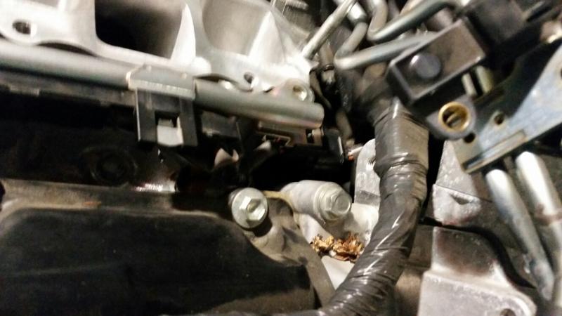 Close up showing the electrical connection that is clipped to the rear of the drivers' side fuel rail.